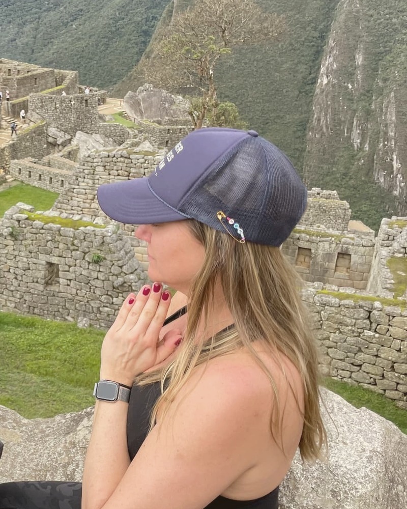 Patricia meditating with hands at her heart at Machu Picchu