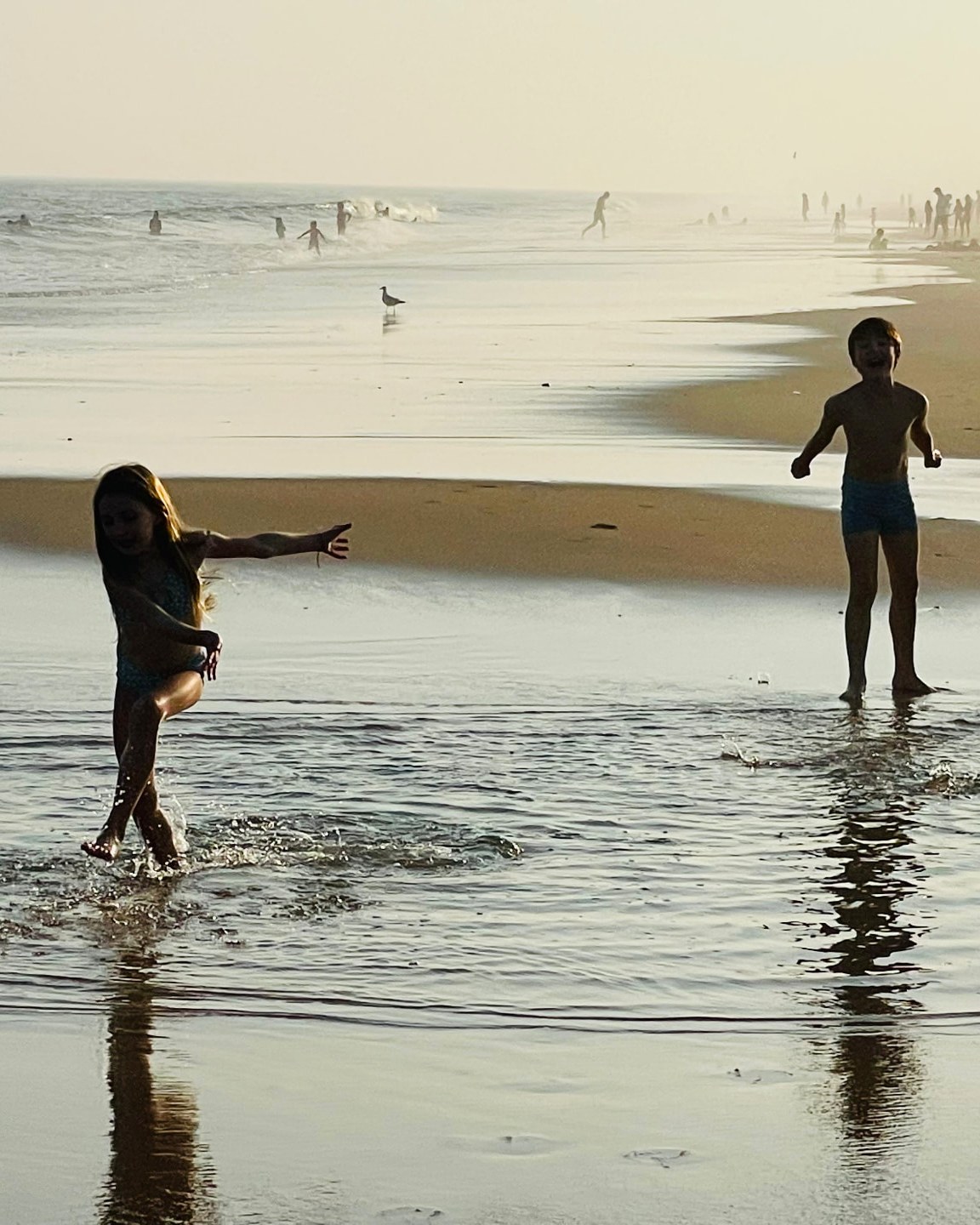 Patricia's two children playing in the surf at sunset