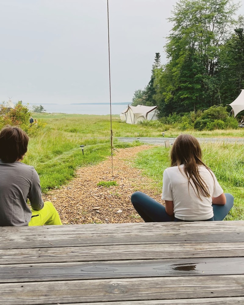 Two people meditating outdoors at a retreat