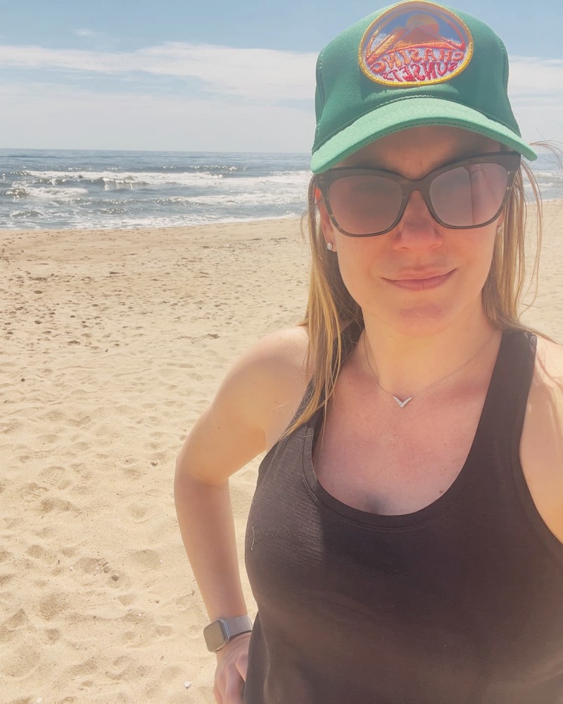 Patricia on the beach with the waves behind her